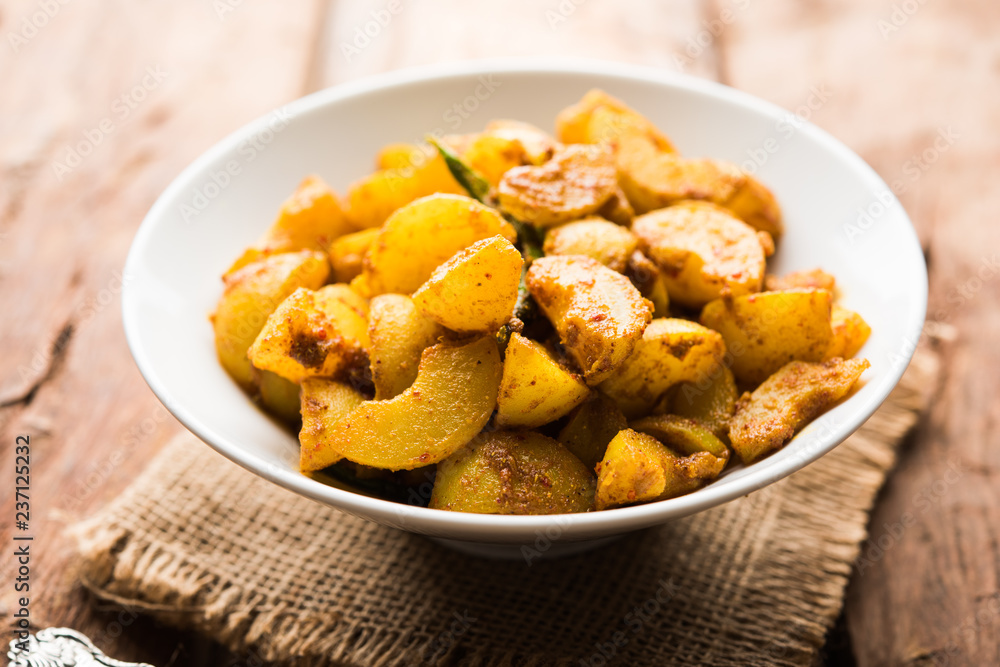 Homemade Gooseberry or amla Pickle/ or Aavle ka Achar in a bowl or barni over moody background. selective focus Homemade Gooseberry or amla Pickle/ or Aavle ka Achar in a bowl or barni over moody background. selective focus