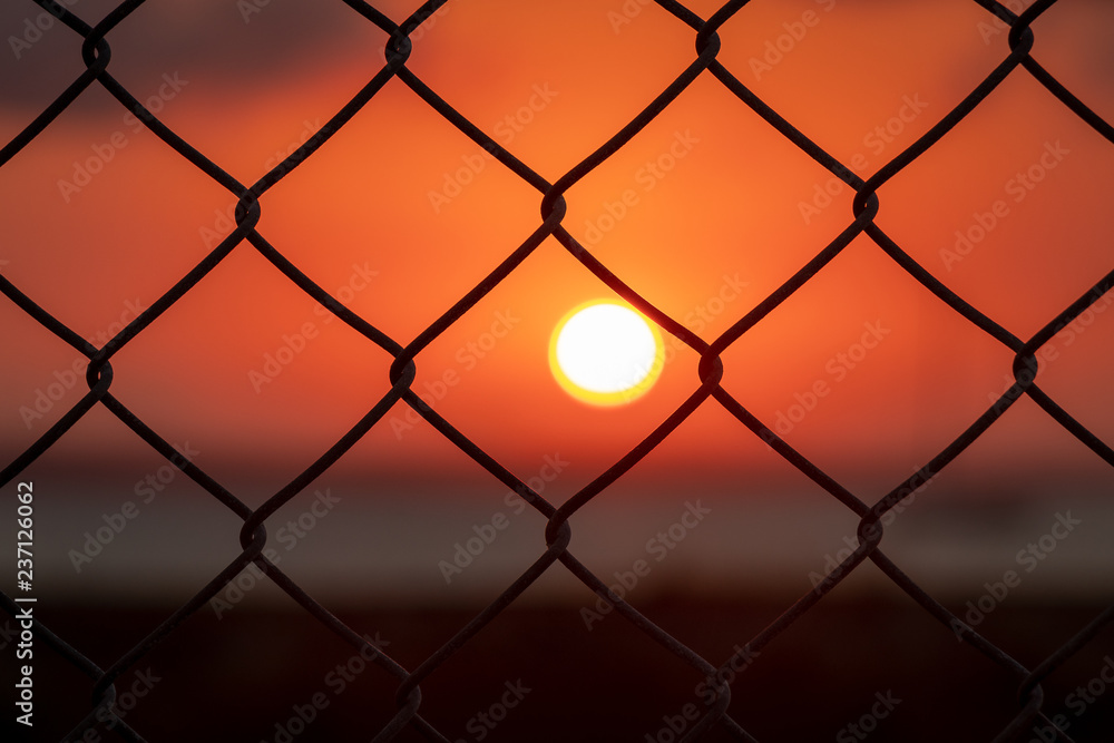Fototapeta premium Sunrise through fence