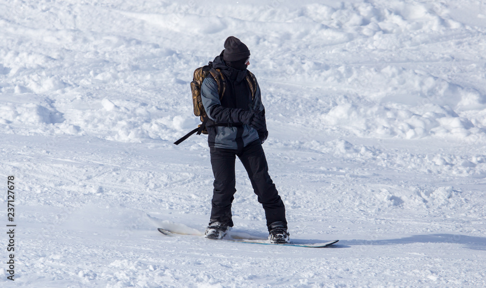 A man snowboarding a mountain in the snow in winter