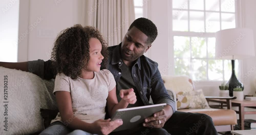 African American father and daughter using digital tablet together African American father and daughter using digital tablet together