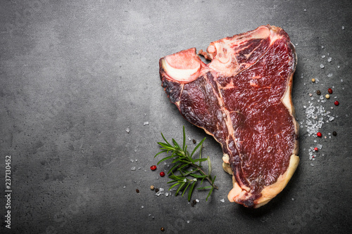 Obraz na plátně Dry aged beef steak t-bone on black slate background.