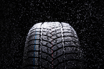 Winter Car tires with snow on black background