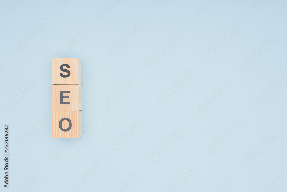 Flat lay of wooden blocks with seo lettering isolated on light blue Flat lay of wooden blocks with seo lettering isolated on light blue