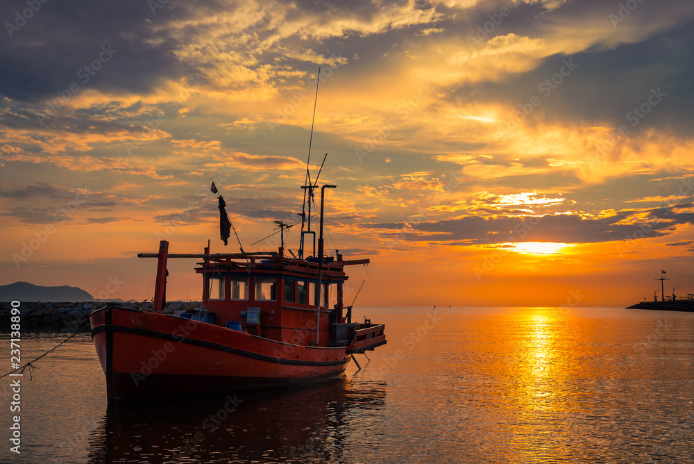 Fototapeta premium Silhouette fishing boat parking on beach at sunset time sky backgroun