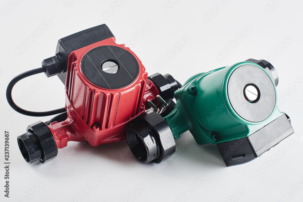 Red and green circulation pumps for heating on a white background. Red and green circulation pumps for heating on a white background.
