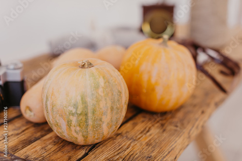 Bright yellow and orange pumpkins on light brown wooden table