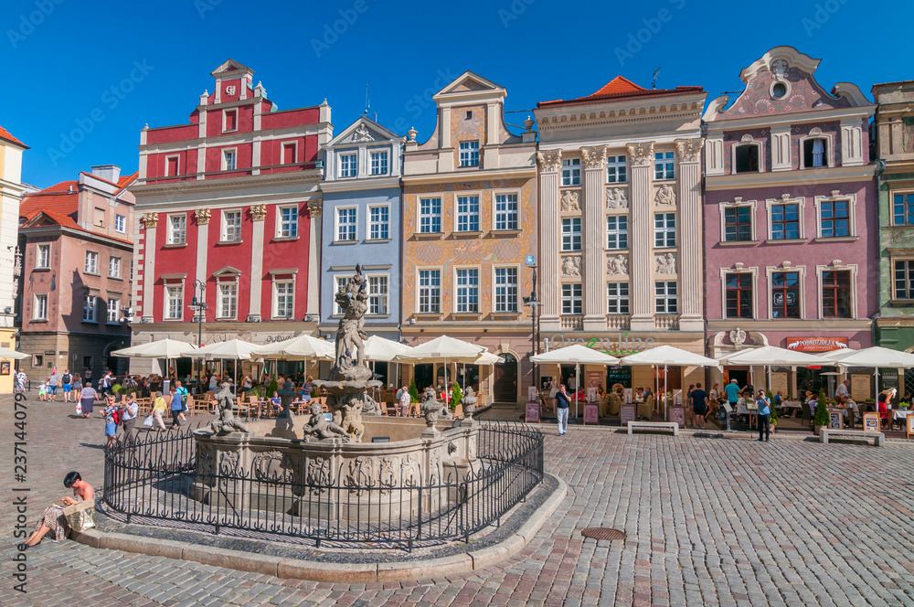 Facades of old houses and fountain on the old Market Square in Poznan, Poland.