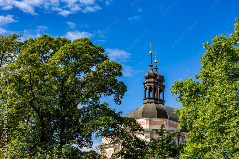 Amazing summer day cityscape  view of two towers in detail of the St. Peter and St. Paul Basilica, Prague, Czech Republic, colorful side view with trees from a green public park