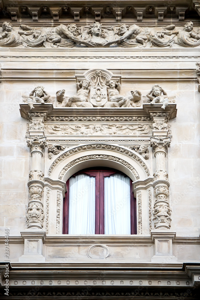 Window decorated with carving and sculptures in neo-baroque style