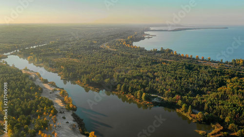 Beautiful river flowing along the forest shooting from a bird's eye view