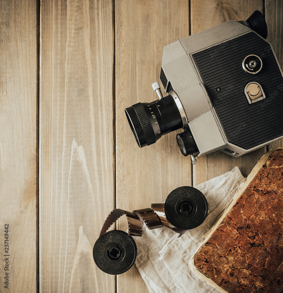Competitive level Part Vintage old movie camera on a wooden table, old book, clothl. Retro photo.  Copy space. Top view. Stock Photo | Adobe Stock