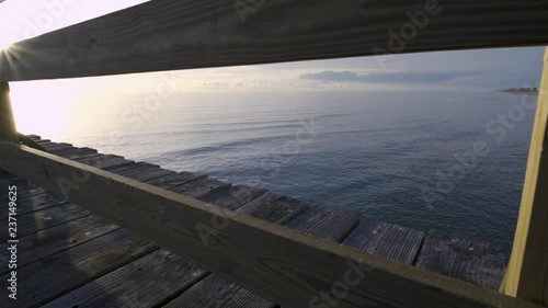 view of the ocean from the fishing looking through the railing 2