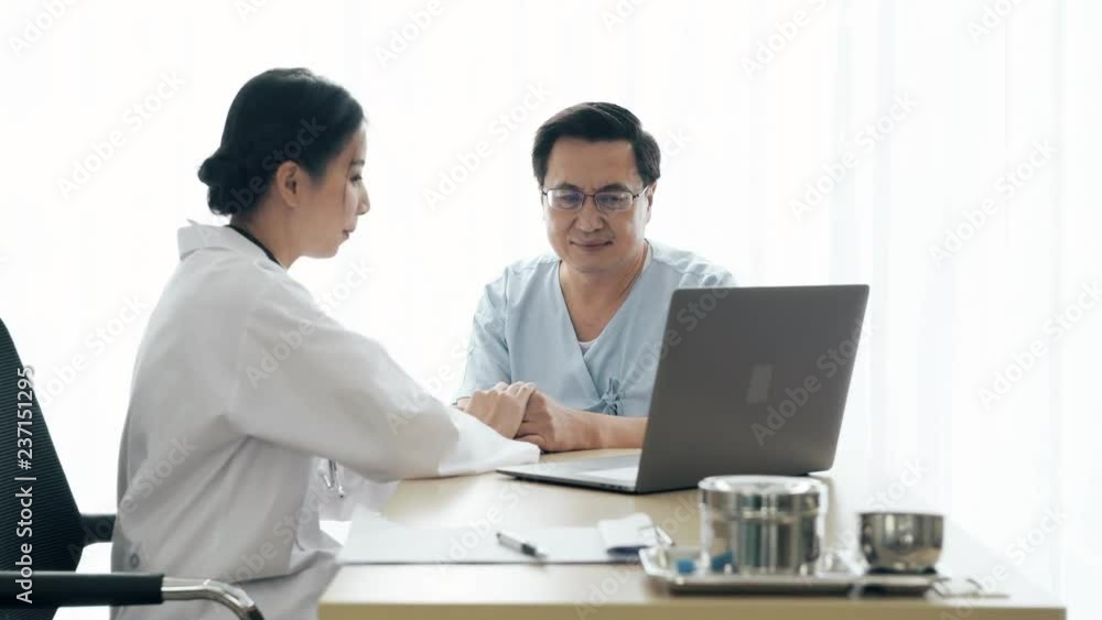 Doctor with patient. Young female medical doctor talking to a senior patient at hospital. Sharing medical test result via computer. Senior care medical and insurance concept.