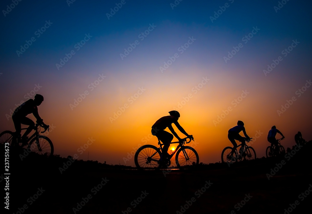 Obraz premium Cyclist in sunset background.