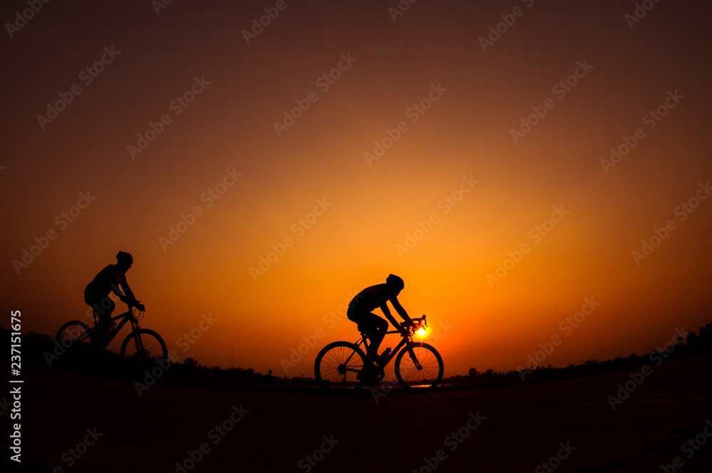 Obraz premium Cyclist in sunset background.