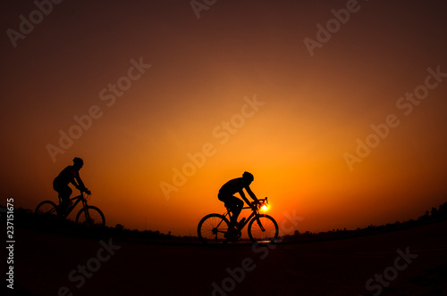 Cyclist in sunset background.