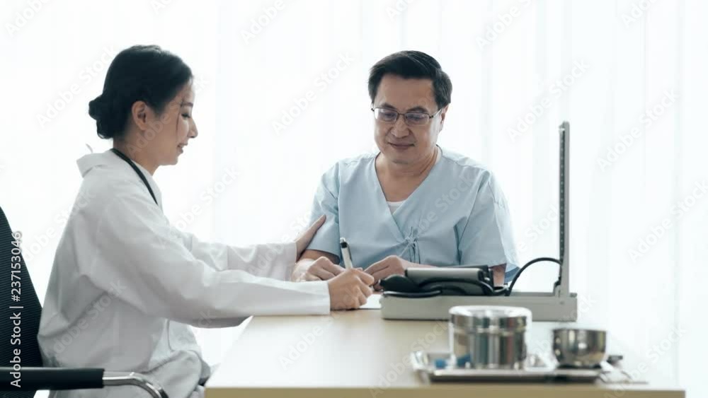 Doctor with patient. Young female medical doctor talking to a senior patient at hospital. Taking notes. Senior care medical and insurance concept. Doctor with patient. Young female medical doctor talking to a senior patient at hospital. Taking notes. Senior care medical and insurance concept.