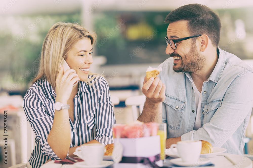 Smiling couple is positively cheerful because of the long-awaited call Smiling couple is positively cheerful because of the long-awaited call