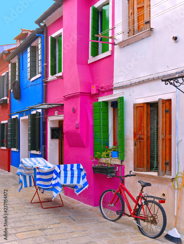 Burano, Italy. View of the colorful houses with windows, laundry cloths to dry outside and bicycle in the small picturesque island of Burano near 
