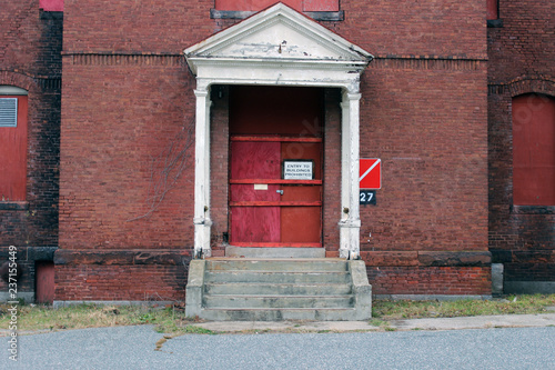 Boarded up and abandoned brick mental hospital asylum building 