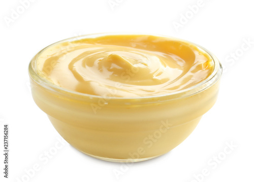 Tasty yellow sauce in bowl on white background
