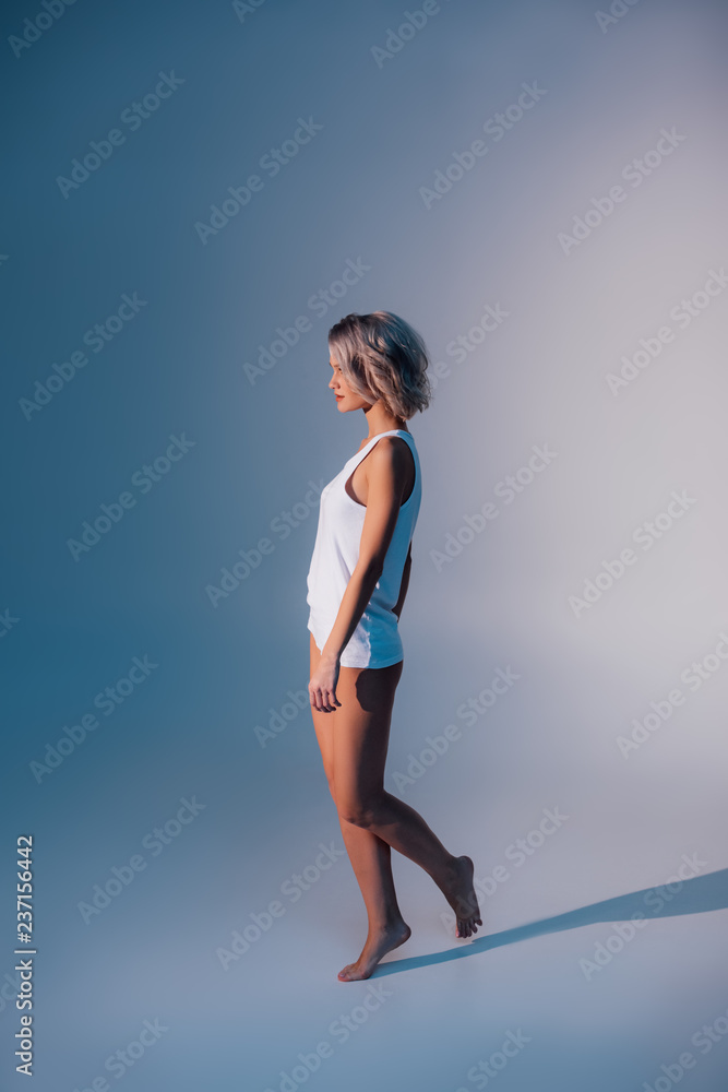 woman in white nightwear posing on dark blue background woman in white nightwear posing on dark blue background