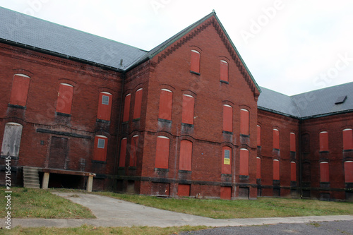 Boarded up and abandoned brick mental hospital asylum building 