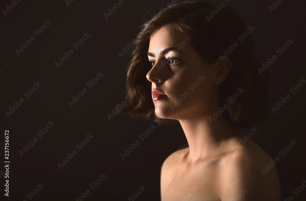 Portrait of beautiful young woman on dark background Portrait of beautiful young woman on dark background