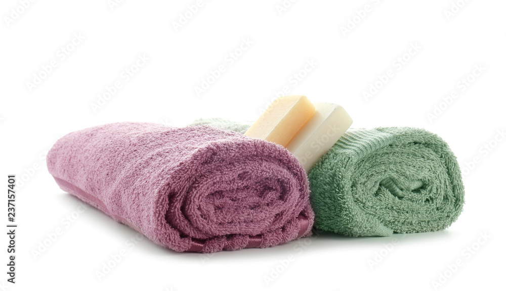 Rolled clean soft towels with soap bars on white background Rolled clean soft towels with soap bars on white background