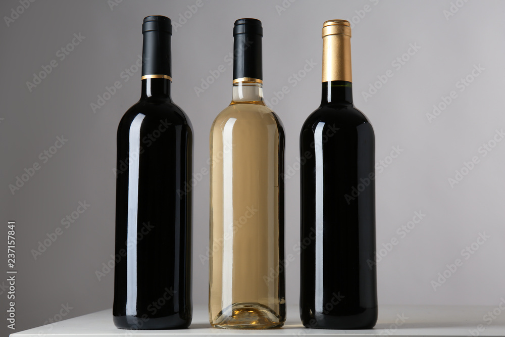 Bottles with different kinds of wine on grey background Bottles with different kinds of wine on grey background