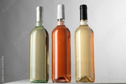 Fototapeta Naklejka Na Ścianę i Meble -  Bottles with different kinds of wine on grey background