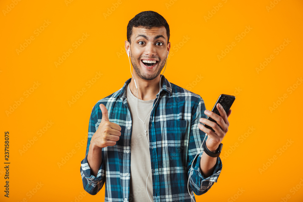 Cheerful young man wearing plaid shirt standing Cheerful young man wearing plaid shirt standing