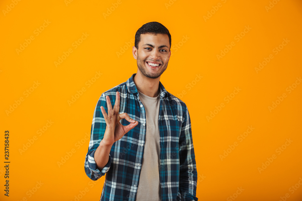 Cheerful young man wearing plaid shirt standing Cheerful young man wearing plaid shirt standing