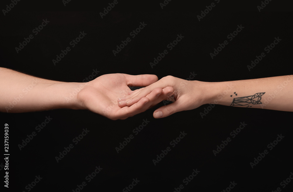 Man and woman holding hands on dark background