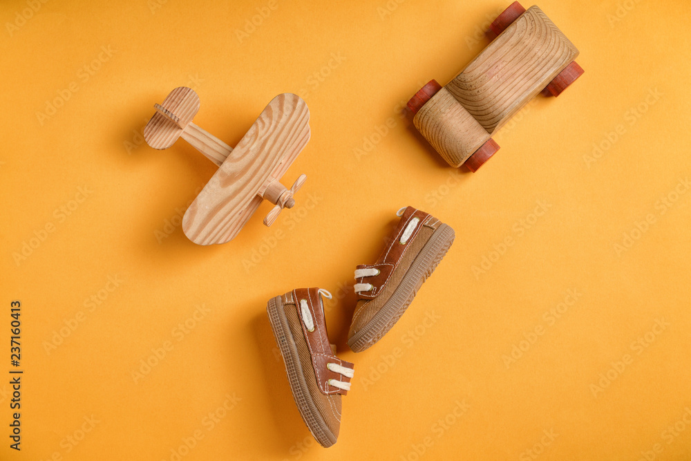 Baby shoes and toys on color background, flat lay Baby shoes and toys on color background, flat lay