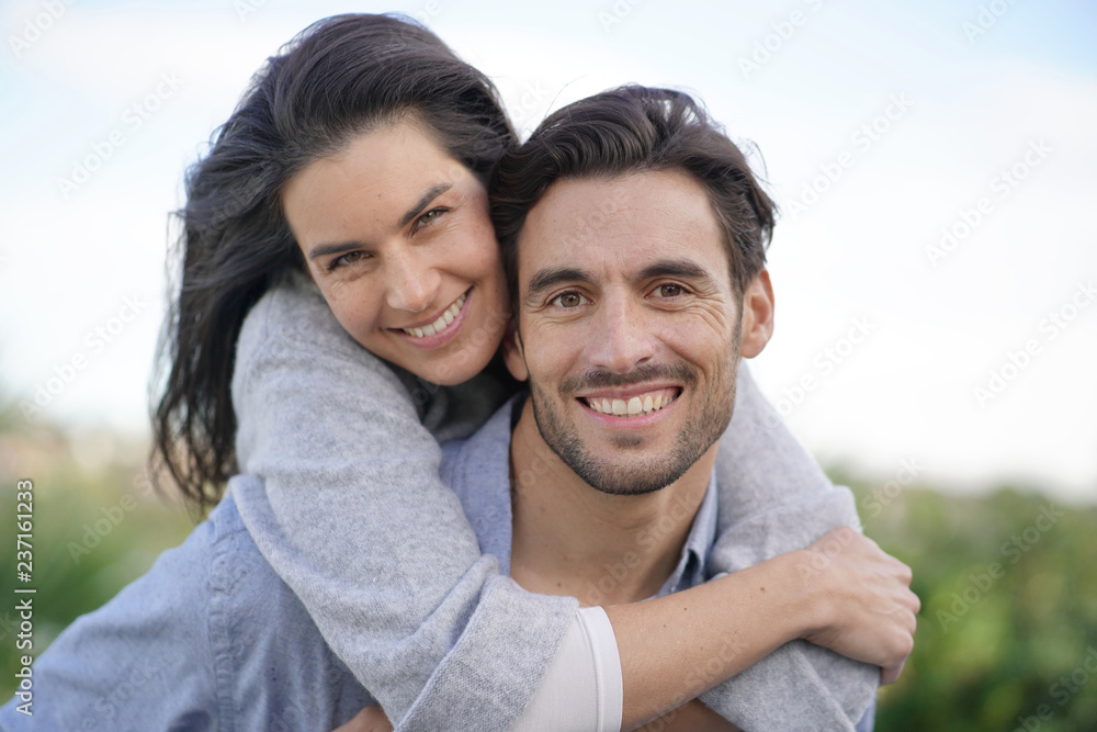 Portrait of gorgeous couple outdoors piggybacking Portrait of gorgeous couple outdoors piggybacking