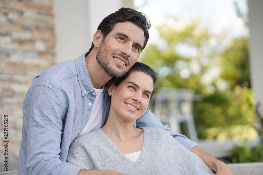  Portrait of very attractive couple smiling outside modern house
