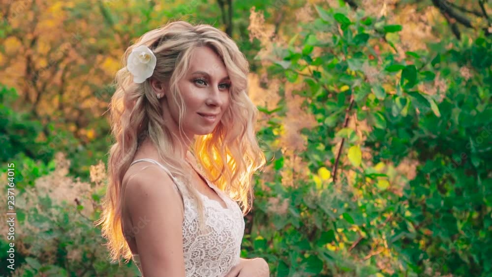 ideal attractive pregnant slim girl with blond hair that soars in a light breeze, during pregnancy, stands in an amazing chic expensive feminine dress in the summer forest with bright warm sun ideal attractive pregnant slim girl with blond hair that soars in a light breeze, during pregnancy, stands in an amazing chic expensive feminine dress in the summer forest with bright warm sun