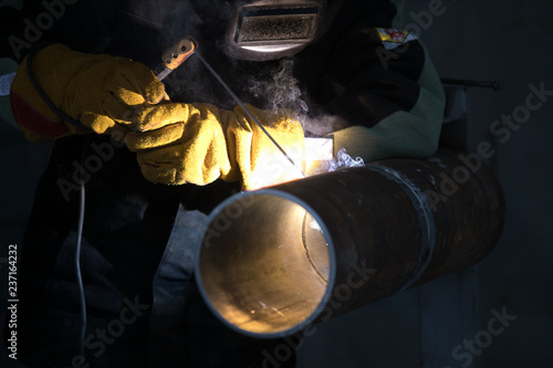 Worker welding metal piping using tig welder