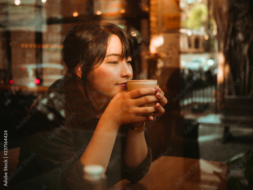Asian woman drinking coffee in  coffee shop cafe