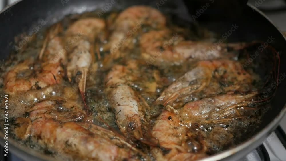 Cooking king prawns with dill and garlic in a pan with olive oil. Cooking king prawns with dill and garlic in a pan with olive oil.