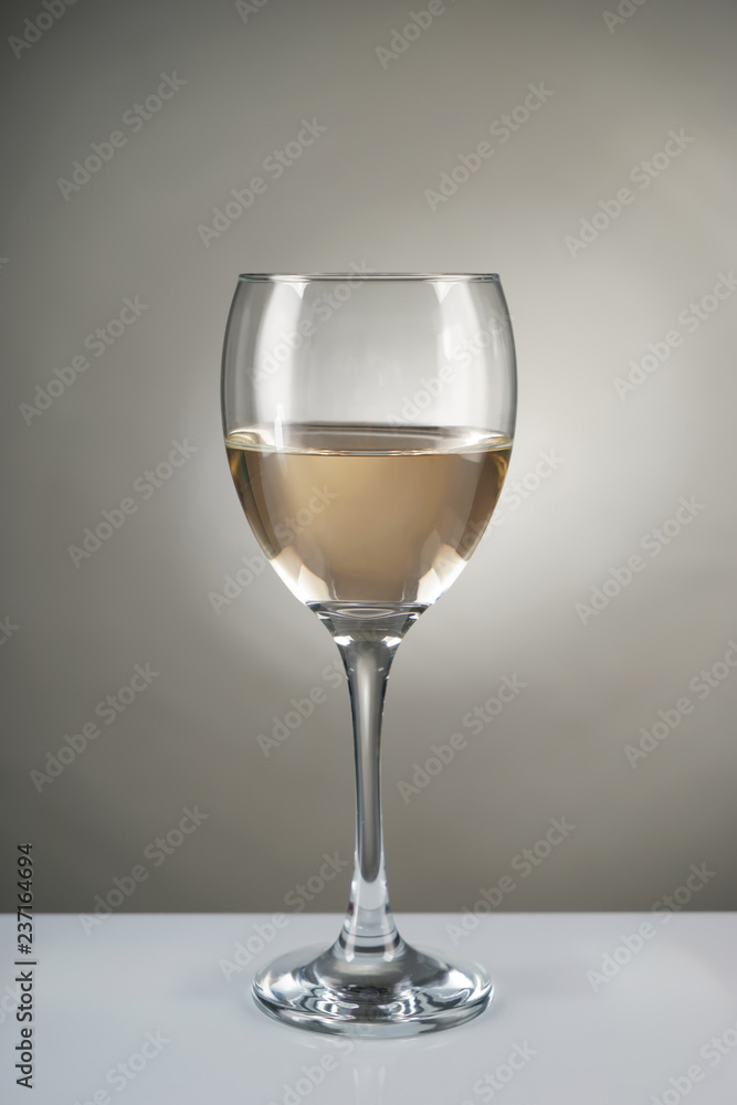 Glass of white wine on grey background Glass of white wine on grey background