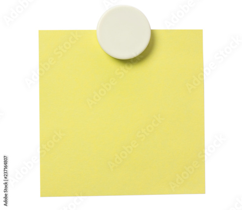 Yellow adhesive note and white magnet button on whiteboard.