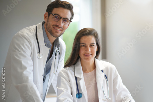 Young doctors in lab coats smiling