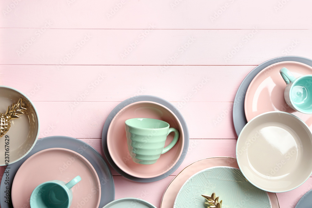 Set of clean tableware on color wooden background Set of clean tableware on color wooden background