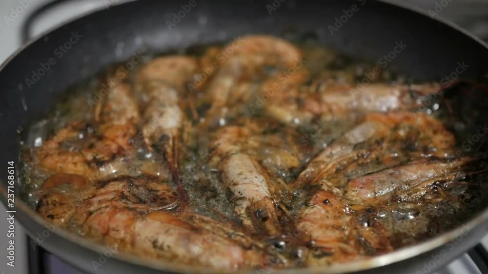 Cooking king prawns with dill and garlic in a pan with olive oil. Cooking king prawns with dill and garlic in a pan with olive oil.