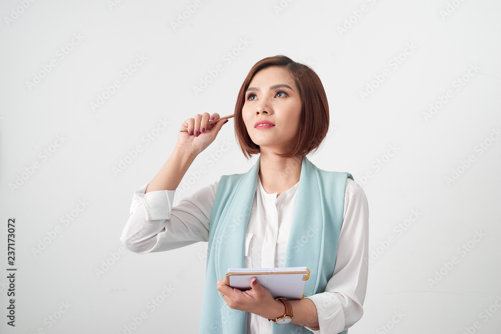 Portrait of young smiling businesswoman in the office, holding documents on light background Portrait of young smiling businesswoman in the office, holding documents on light background