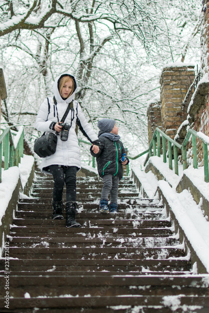 Mom and son walk down the stairs in the winter. Mom and son walk down the stairs in the winter.