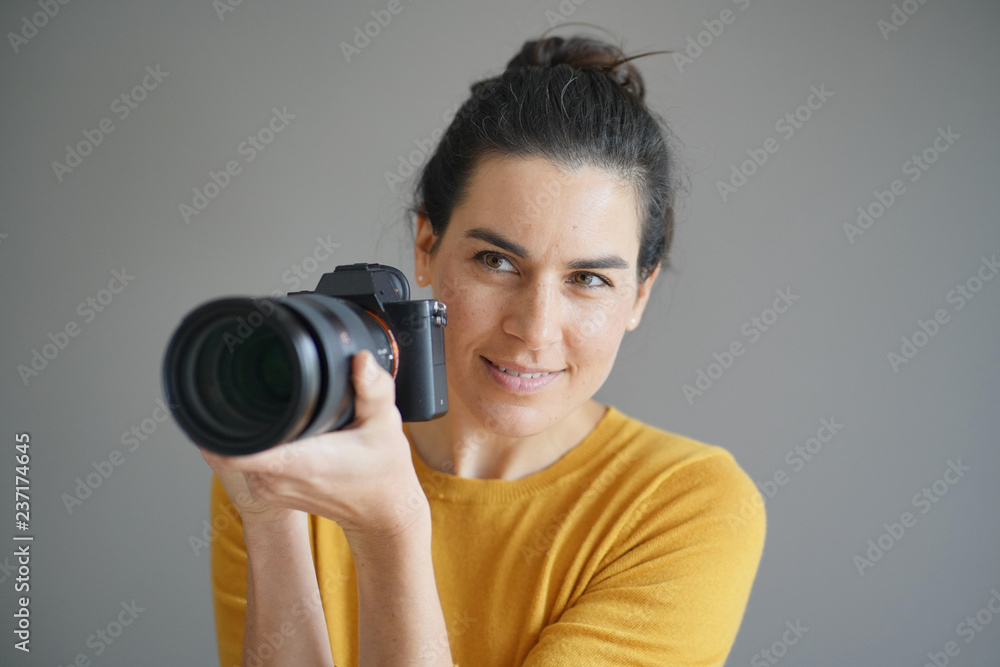 Portrait of stunning brunette photographer on grey isolated background Portrait of stunning brunette photographer on grey isolated background