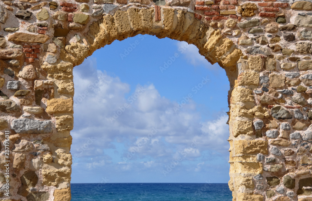 Sea view through an ancient stone arch in Sicily on a sunny day Sea view through an ancient stone arch in Sicily on a sunny day